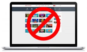 Laptop Open with Bovada Site Displaying Casino Homepage with Games, Red X Blocking Site